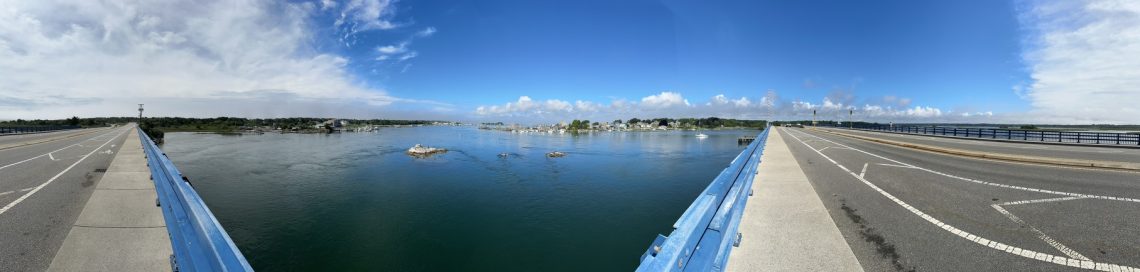Panoramic photograph of a riverway and draw bridge.