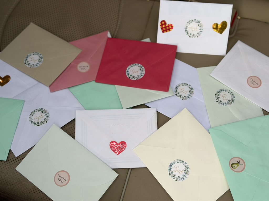 A smattering of brightly colored thank you cards in envelopes sealed with stickers.